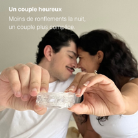Couple heureux tenant l'orthèse mandibulaire anti-ronflement CalmNox - moins de ronflements la nuit - couple plus complice